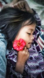 Close-up portrait of a girl holding pink flower