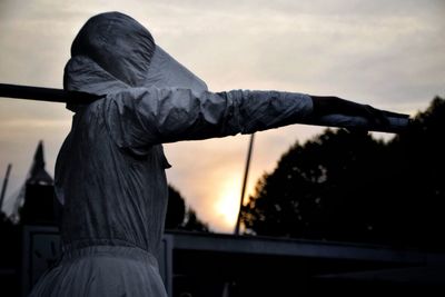 Silhouette of woman against cloudy sky