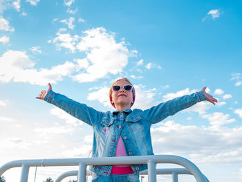 Little girl raised arms blue sky. happy child smiling flying in the air. lifestyle freedom happiness