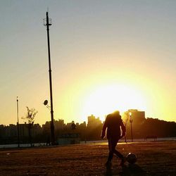 People standing on road at sunset