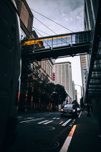 Cars on road against sky in city