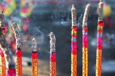 Close-up of multi colored candles in temple