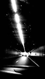 Cars on road in illuminated tunnel