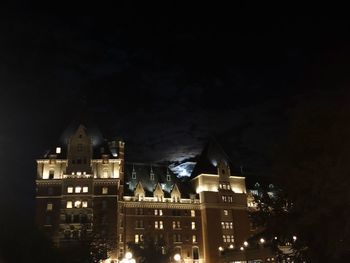 Low angle view of illuminated buildings against sky at night