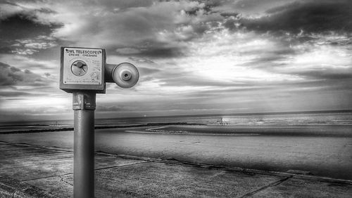 Information sign on beach against sky