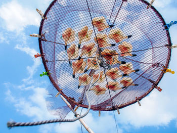 Low angle view of fishing net against blue sky