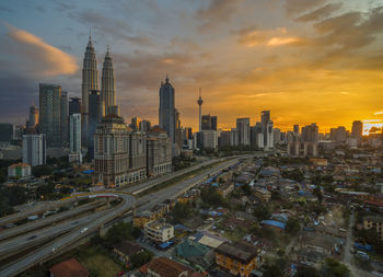 Aerial view of buildings in city during sunset