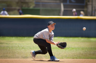 Little league infielder about to catch a baseball