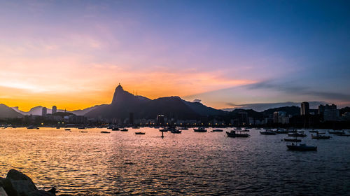 Sailboats in sea against sky during sunset