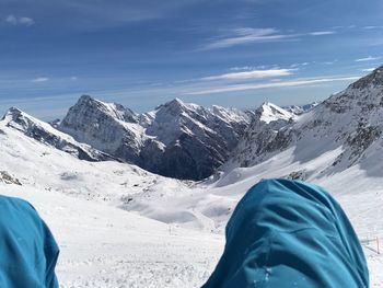 Midsection of man on snowcapped mountain against sky