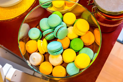 High angle view of multi colored macaroons in container