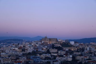 Aerial view of townscape against sky at dusk