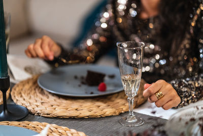 From above of unrecognizable people sitting at table at home and enjoying christmas cake during party