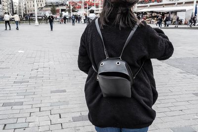 Woman standing on footpath in city