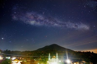 Scenic view of illuminated mountains against sky at night