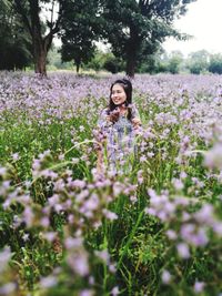 Young woman with flowers in field