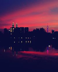 Illuminated cityscape against sky at sunset