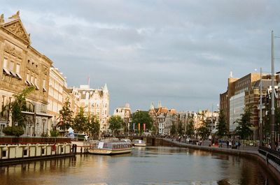 River amidst buildings in city against sky