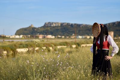 Rear view of woman on field against sky