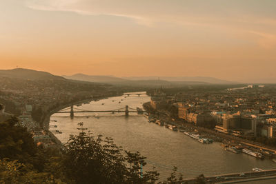 High angle view of river amidst city against sky during sunset
