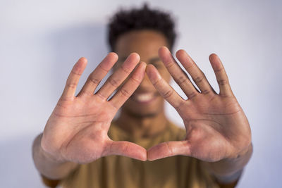 Young man gesturing against white background