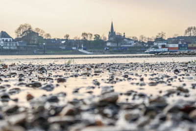 Scenic view of river by buildings against sky