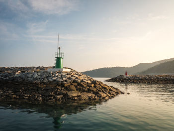 Lighthouse amidst sea, against sky