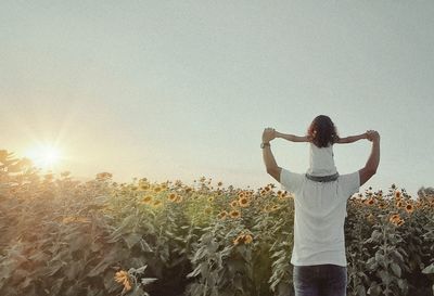 Rear view of woman standing against bright sun