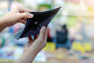 Close-up of woman holding empty wallet outdoors