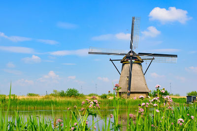 Traditional windmill on field against sky