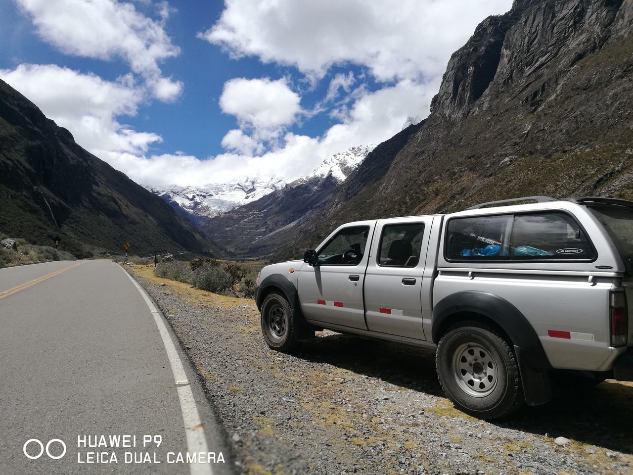 VINTAGE CAR ON ROAD AGAINST MOUNTAIN RANGE