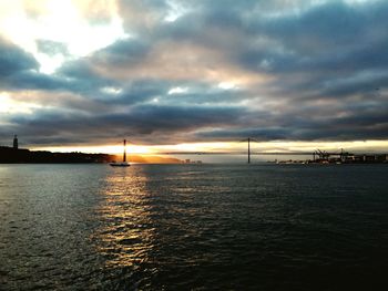 Scenic view of sea against dramatic sky during sunset