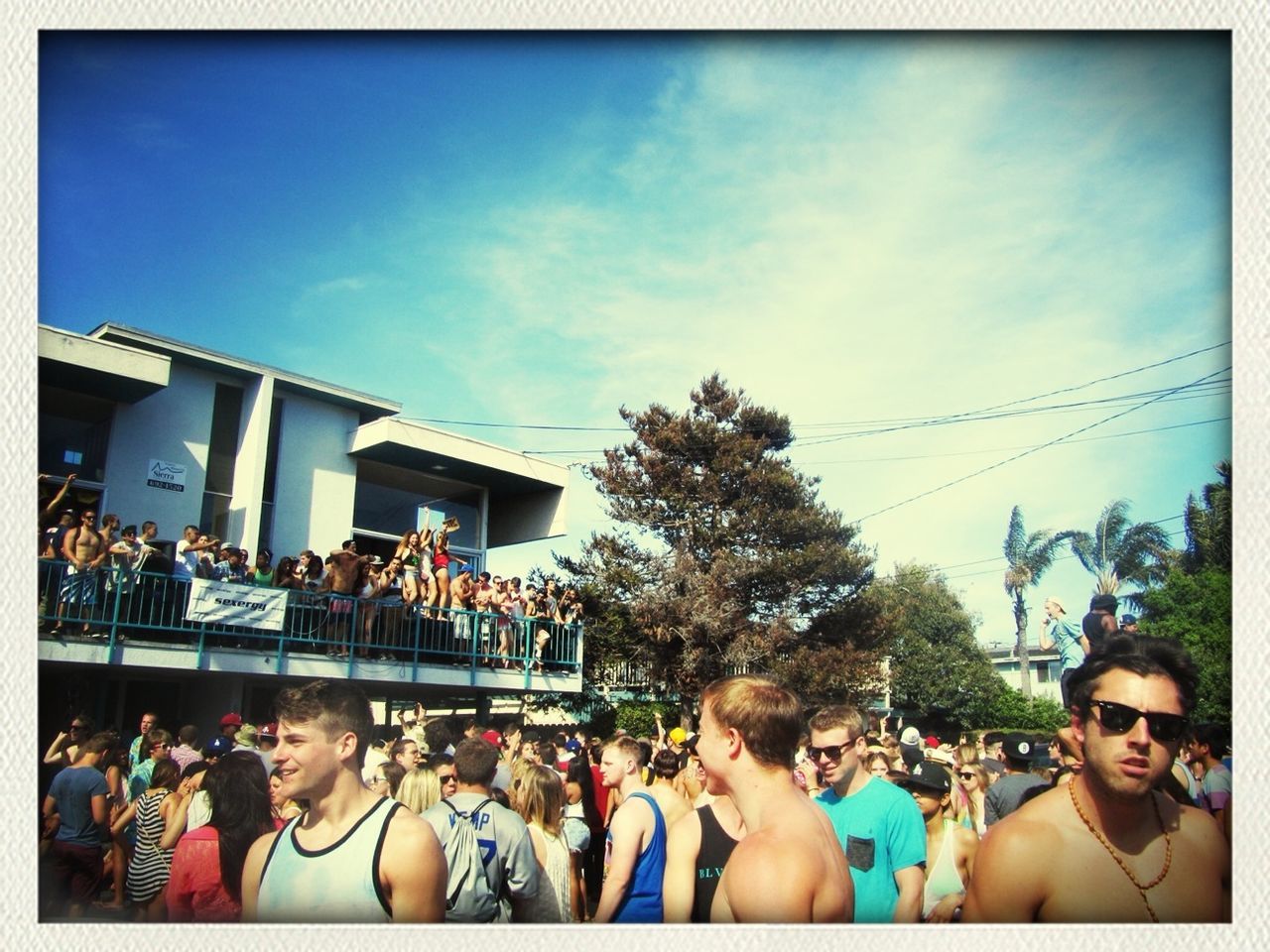 large group of people, transfer print, lifestyles, person, men, leisure activity, sky, auto post production filter, building exterior, architecture, built structure, tree, crowd, mixed age range, togetherness, city life, city, day, street