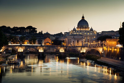 Arch bridge over river against buildings in city