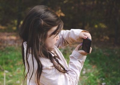 Side view of girl using mobile phone