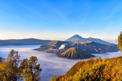 Scenic view of volcanic mountain against blue sky