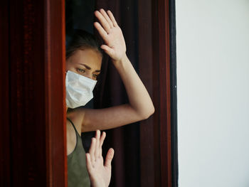 Portrait of woman standing by window