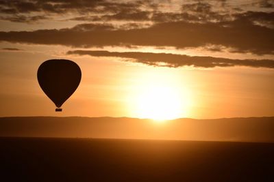 Silhouette of hot air balloon against sky during sunset