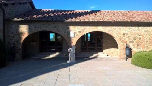 People walking on footpath by historic building