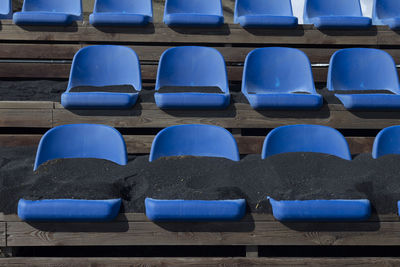 Close up and front view of seats in a row covered by lava sands