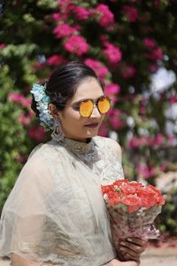 Close-up of woman wearing sunglasses standing against red rock