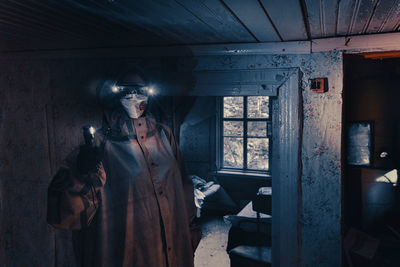 Fictional movie poster. people with flashlights, masks and protective clothing inspect old house. 