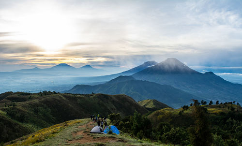 Rear view of people on snowcapped mountains against sky