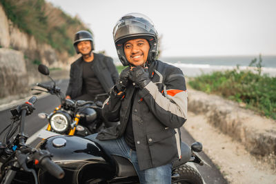 Portrait of man riding motorcycle on road