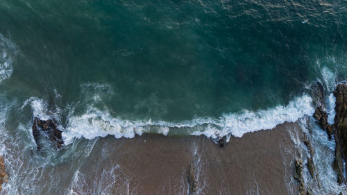 High angle view of sea waves splashing on shore