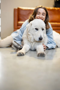 Portrait of woman with dog sitting on floor