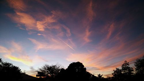 High section of silhouette trees against scenic sky