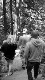 Rear view of woman standing on tree trunk