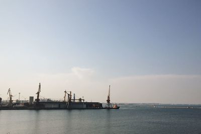 Commercial dock by sea against clear sky