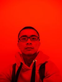 Portrait of man against red background